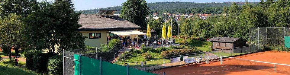 Blick über die Tennisanlage des TC Niedernhausen mit Sandplätzen und der Terrasse des Clubhauses